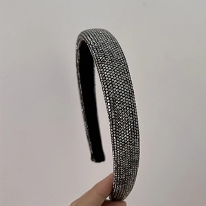 Dettaglio di strass grigio scuro su un cerchietto spesso con fodera antiscivolo