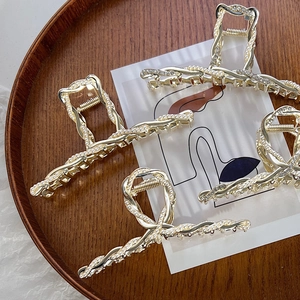 Eleganti mollette per capelli in lega dorata con perle e strass su vassoio