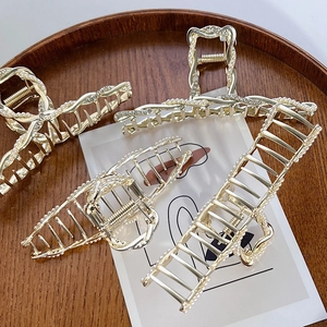 Eleganti mollette per capelli in lega dorata con perle e strass su vassoio in legno