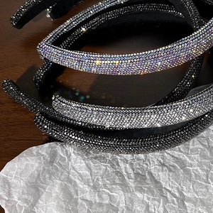 Primo piano di cerchietti spessi con strass densi in argento, nero e colori dell'arcobaleno