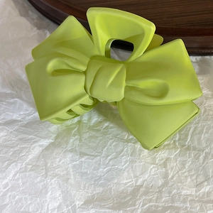 Detailed view of large neon green bow hair claw clip with a stylish matte resin finish