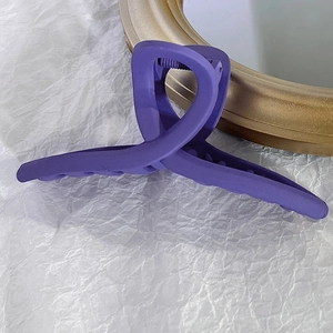 Détail d'une grande pince à cheveux violette mate avec un ressort métallique robuste