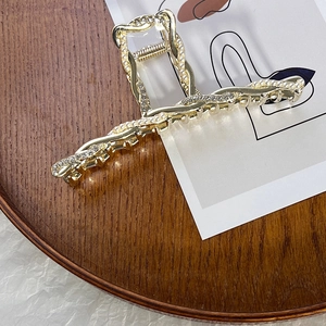 Dettaglio molletta per capelli dorata con perle eleganti e strass scintillanti