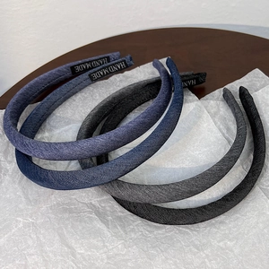 Detailed macro view of denim fabric headbands showing vintage texture and hand made label