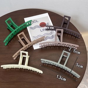Set of 6 large matte claw clips in earth tones on a wooden table, 13cm shark hair clips