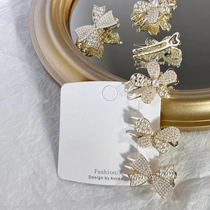 Elegant gold metal hair clip set with white pearls in butterfly and flower shapes
