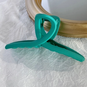 Détail d'une grande pince à cheveux turquoise mate avec ressort en métal résistant