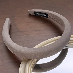 Macro shot of taupe sponge headband showing ribbed texture and handmade label