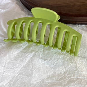 Detailed view of the matte lime green hair claw clip with its durable interlocking teeth