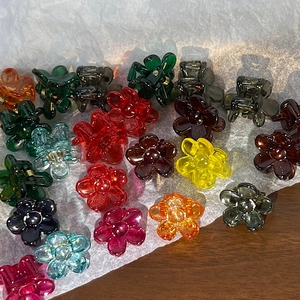 Detailed top view of mini flower-shaped resin hair clips in various vibrant colors