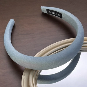 Detailed macro view of light blue padded sponge headband with handmade woven label detail