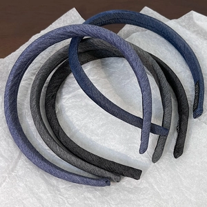 Close-up of four-piece set thin fabric headbands with handmade labels in blue and grey tones