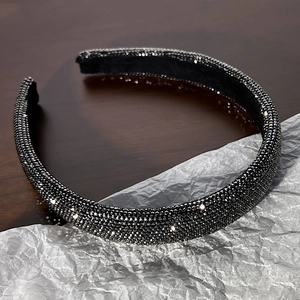Dettaglio di scintillanti strass grigio scuro su un cerchietto elegante e alla moda