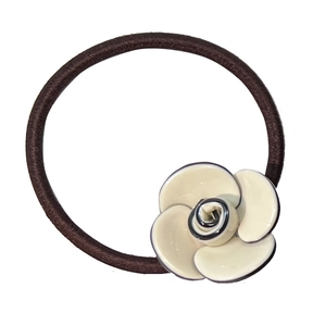Brown elastic hair tie featuring a beige camellia flower charm on white background
