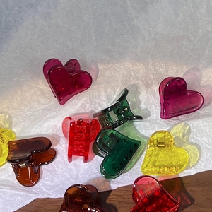 Détail de mini pinces à cheveux en forme de cœur aux couleurs acidulées translucides