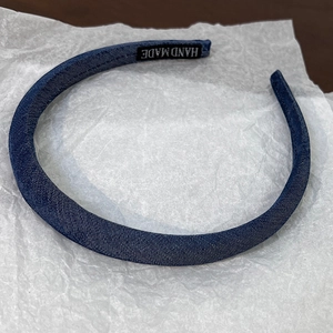 Detailed close-up of the vintage denim blue headband fabric texture and handmade label