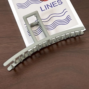 Detail of large matte grey shark hair claw clip with reinforced metal spring and long teeth