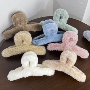 Selection of large plush hair claws in seven autumn colors displayed on a wooden table