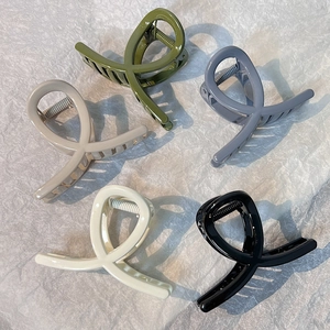 Minimalist cross hair claws in olive, blue, beige, cream, and black on grey background