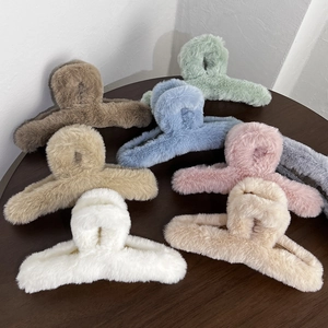 Detailed arrangement of soft plush shark hair clips in assorted neutral colors on wood