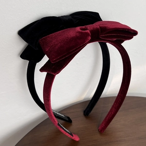 Detail of velvet bow headband showing handmade label and soft vintage fabric texture
