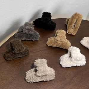 Elegant plush hair claw clips in various colors on a wooden table for autumn winter