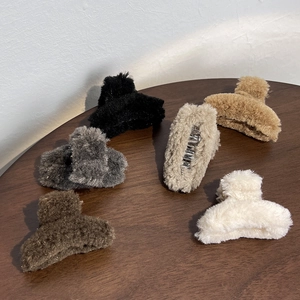 French style plush hair claws in six earthy colors on a wooden table for winter hair styling