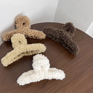 Vue détaillée de quatre pinces à cheveux en peluche aux tons neutres café et beige