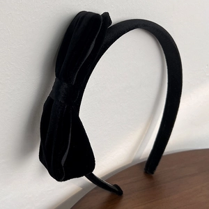 Detail shot of vintage black velvet headband featuring a large side-placed bow design