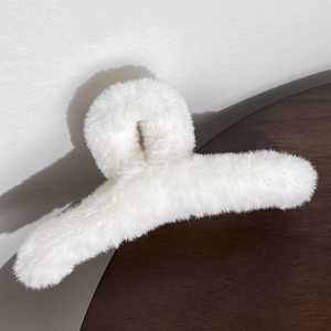 Detailed view of the large white plush hair claw clip with soft faux fur texture