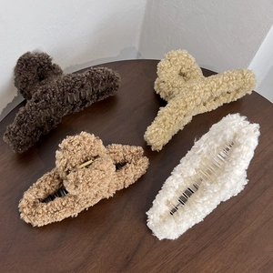 Lot de quatre pinces à cheveux en peluche aux tons café chaud sur une table en bois