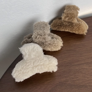 Detail showing soft plush hair claws in white and brown on a wooden surface