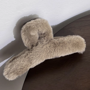 Detail of plush khaki shark clip showing soft faux fur texture for autumn hair styling