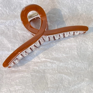 Dettaglio di una pinza per capelli da 13cm marrone traslucido con molla in metallo forte