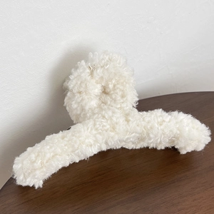 Détail de la grande pince à cheveux blanc crème avec texture en peluche douce