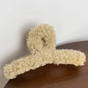 Détail de la pince à cheveux en peluche douce montrant la texture de fausse fourrure bouclée