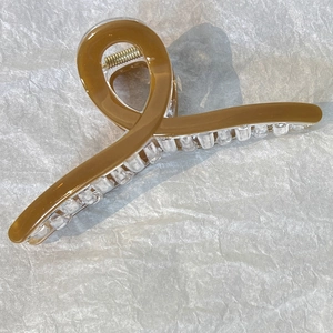 Dettaglio della molletta per capelli caramello da 13cm con denti trasparenti e molla