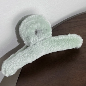 Detail view of the soft light green plush material on this elongated hair claw clip