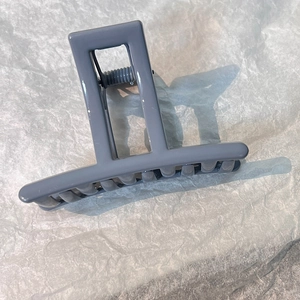 Detail of grey hair claw clip with square frame handle and polished finish