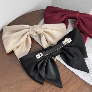 Elegant satin bow hair clip set in wine red, champagne and black on a wooden background