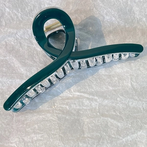 Dettaglio di un grande fermaglio per capelli verde scuro da 13cm con molla dorata