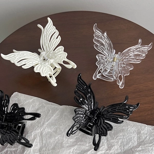 Elegant butterfly hair claws in black, cream, and clear resin for stylish hair styling
