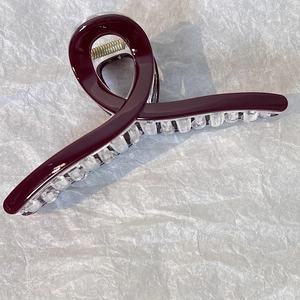 Dettaglio di un fermaglio per capelli bordeaux da 13cm con denti trasparenti e molla