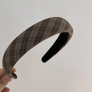 Detailed macro view of the brown plaid fabric texture and thick padded headband design