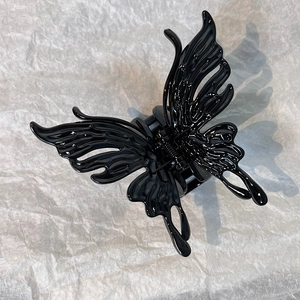 Macro shot of liquid metal black butterfly hair claw clip with gothic hollow design