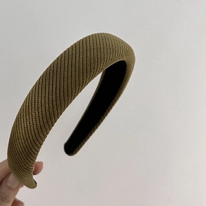 Detail view of olive green ribbed fabric and padded sponge layer on the thick headband