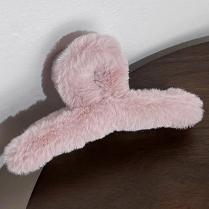 Pink plush hair claw clip with soft faux fur texture and elegant curved design