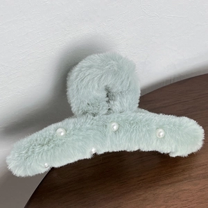 Detail view of mint green plush hair claw clip with white pearl accents for autumn hair styling