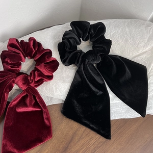 Detail view of black and burgundy velvet bow hair scrunchies with long elegant ribbons