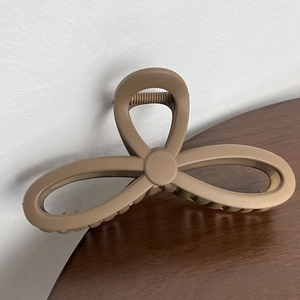 French retro matte khaki bow hair claw clip for elegant updo hairstyles on wood background